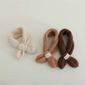 Detailed knit texture of children ribbed crossover scarves in beige and brown colors