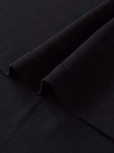 Macro view of black crepe fabric texture showing detailed weave and knit structure