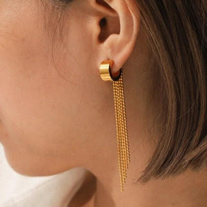 Close-up of gold stainless steel tassel earrings featuring bead chains on a female model