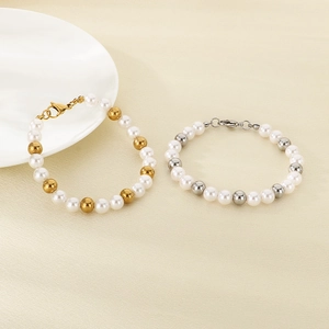 Minimalist stainless steel beaded bracelet set with white pearls on a neutral background