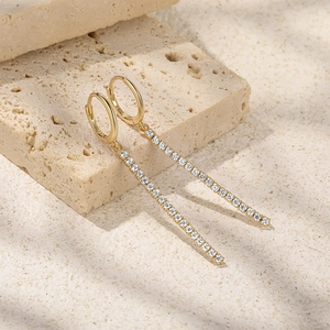 Close-up of gold S925 sterling silver tassel earrings with white zircon accents