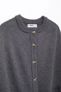 Close-up of dark grey knitted cardigan featuring single-breasted buttons and neckline detail