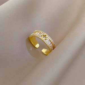Verstellbarer vergoldeter Kleeblatt-Ring mit Kristallen und Stern auf Seidenhintergrund