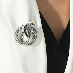 Macro shot of silver cobra snake brooch with vintage finish on a white suit lapel