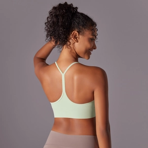 Close-up of mint green racerback sports bra showing thin straps and back muscle lines