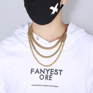 Detailed view of layered golden Cuban link necklaces in three sizes on a male model