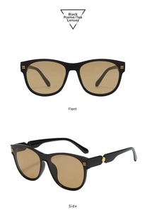 Detail view of oval black frame sunglasses with tea lenses and golden side accents