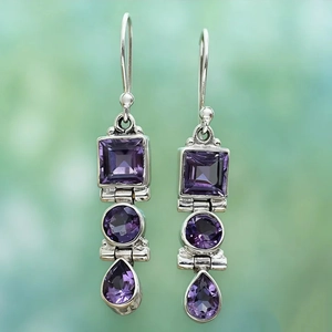 Macro shot of vintage silver earrings with three-tier purple amethyst crystals in teardrop shape