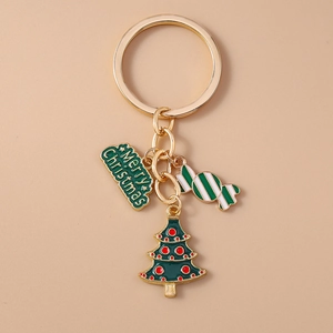 Detailed close-up of Christmas tree and candy cane pendants on a golden metal keychain