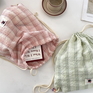 Detail of trendy checkered canvas drawstring backpack with cotton rope in pink and green