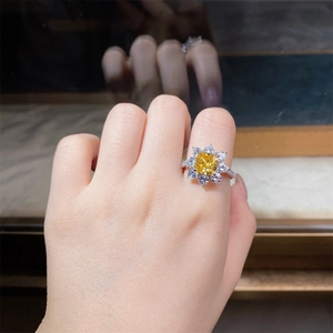 Macro shot of silver ring with yellow cushion-cut stone and halo of small diamonds