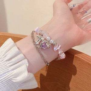 Detail of double-layer beaded bracelet with pink heart crystal and silver bow charm