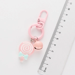 Lollipop keychain detail showing 9.5cm length measurement with a ruler and pink bell