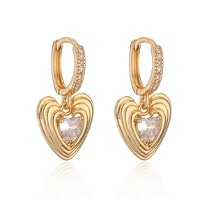 Boucles d'oreilles cœur plaquées or avec zircons sur fond blanc avec reflet