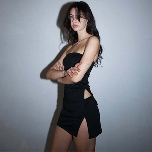Detailed view of the side slit and waist cutout on this black slim-fit mini skirt set