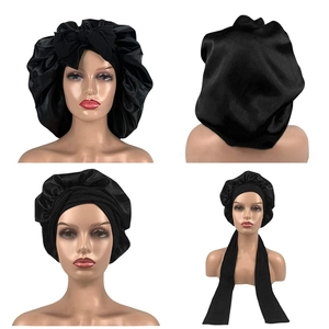 Black satin sleep bonnet with adjustable long straps and bow detail for hair care