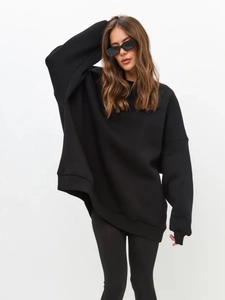 Detail of oversized black crewneck sweatshirt showing loose-fit drop shoulder design