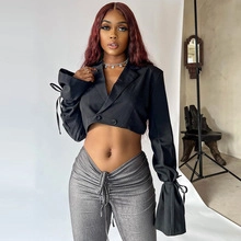 Detail view of cropped black blazer and grey drawstring trousers on fashion model