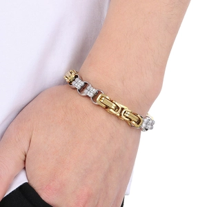 Close-up of gold and silver two-tone stainless steel chunky chain bracelet on male wrist