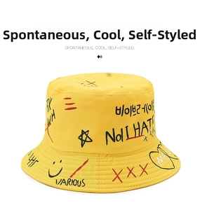 Detail of yellow canvas bucket hat featuring black and red street style graffiti prints