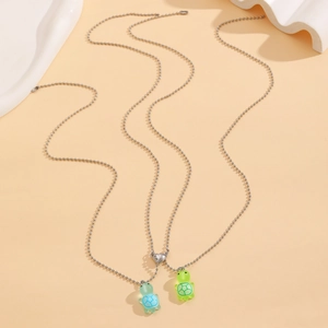 Close-up of magnetic heart clasp connecting blue and green luminous turtle necklaces