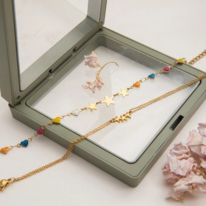 Gold star and colorful heart charm bracelet set displayed on a minimalist gift box