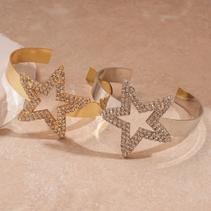 Detail of metal bangle featuring a large star-shaped design encrusted with sparkling rhinestones