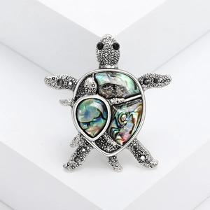 Vintage silver turtle brooch featuring colorful abalone shell inlay and black crystals