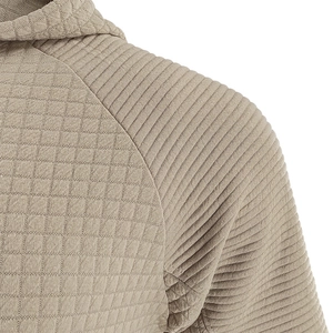 Detailaufnahme der beigen Waffelstrick-Textur und der Rippnähte eines Herren-Hoodies