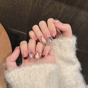 Close-up of Christmas themed press-on nails with red gradient, 3D trees and stars