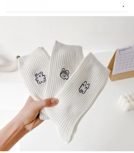 Detailed view of white ribbed socks featuring cute bear and rabbit cartoon embroidery