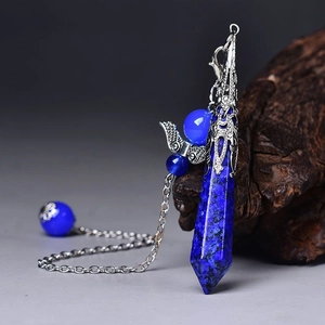 Macro shot of lapis lazuli hexagonal pendant with silver filigree and small wing charms