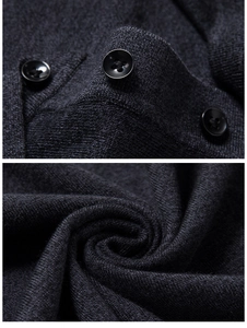 Macro detail of dark grey knit fabric texture and premium black buttons on a men's sweater