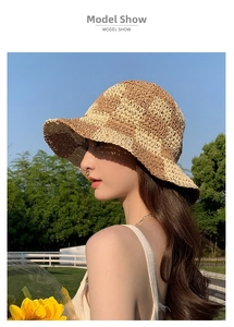 Outdoor model wearing a checkered woven straw bucket hat with beige and brown textures