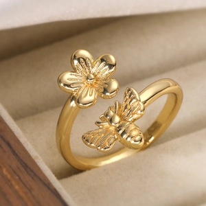 Minimalist 18K gold plated flower and bee adjustable ring displayed on a velvet jewelry box