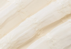 Détail du tissu blanc plissé pour une robe d'été dos nu avec licou et texture douce