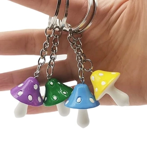 Set of four colorful resin mushroom keychains with white dots on a polished silver ring