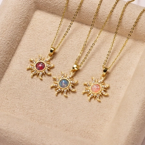 Detalle de tres collares de girasol chapados en oro con piedras rojas, azules y rosas