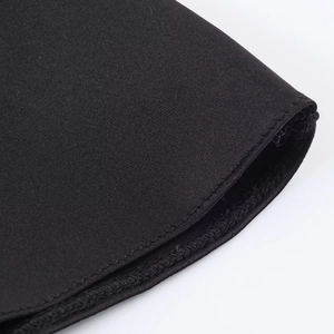 Detailed close-up of smooth black satin fabric texture and precise stitching craftsmanship