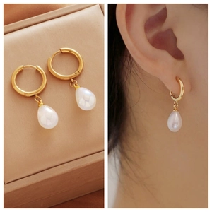 Detail view of gold hoop pearl earrings with model showcase and white drop pearl charm