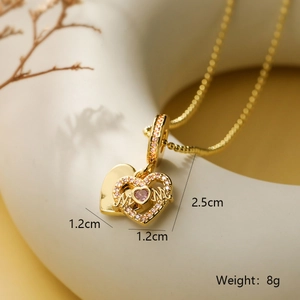 Dettaglio macro della collana a cuore placcata in oro con zircone rosa e scritta MOM incisa