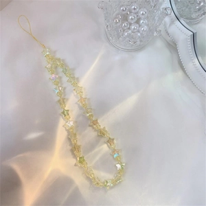 Rainbow yellow star beaded phone charm with iridescent finish on soft fabric backdrop