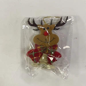 Detail of Christmas reindeer ornament with red plaid scarf and gold metal bell
