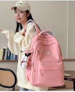 Pink durable nylon backpack with multiple compartments and cute plush puppy charm