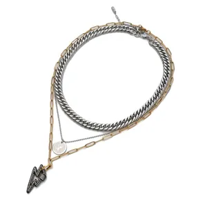 Detailed view of triple-layered necklace with coin pendant and lightning bolt charm