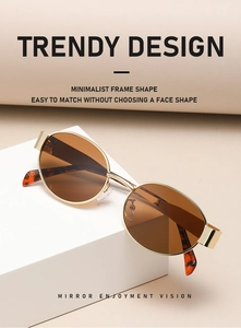 Detail of vintage oval sunglasses with gold metal frame and brown lenses on block