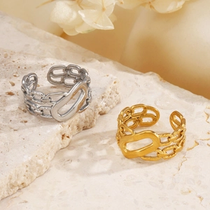 Minimalist 18K gold and silver chain link open rings on textured stone background