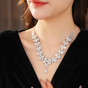 Macro shot of silver sunflower necklace with sparkling diamonds worn by a model