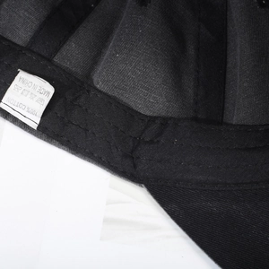 Internal detail of a black washed cotton baseball cap with 100% cotton label