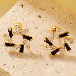 Détail macro de boucles d'oreilles fleur dorées avec cristaux trapèzes noirs et clairs